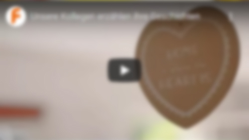 Video - Unsere Kollegen erzählen Ihre Geschichten Herzaufhänger im Vordergrund mit Aufschrift - Home Sweet Home